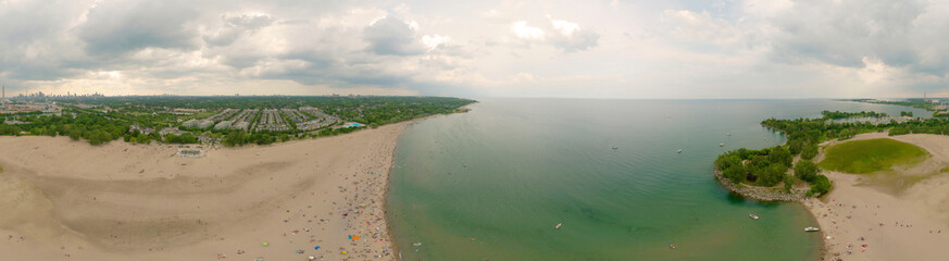 Toronto Woodbine Beach and sandy beach with people swimming, aerial view, Ontario, Canada, rainy cloudy greenery coast with boats at summer. Many residential houses. Popular tourist location