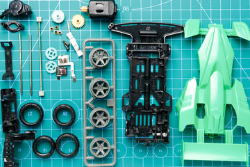 Flatlay mini 4WD toy cara awaiting to be assemble on cutting mat. Popular toy car during 90's.