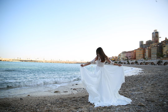 The bride in a wedding dress holds hands near the sea in Monaco. Wedding day.