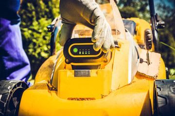 Replacing the battery from the mower. The gardener replaces the battery, the concept of caring for the garden, mowing the grass. Allotment season. Caring for electricity in the mower.