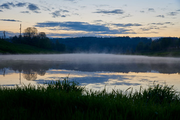 On a misty spring evening landscape. Fog over the river and forest. The beauty in nature.