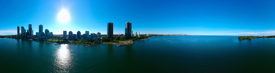 Fototapeta premium Humber Bay Shores Park city views, green space with skyline cityscape downtown, azure lake Ontario. Skyscrapers over The Queensway on sunset at summer time, near Etobicoke or Toronto, Ontario, Canada