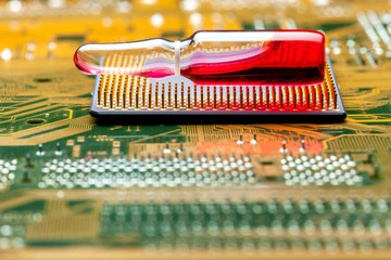 glass ampoule for vaccination implantation processor chip implantation for surveillance and verification human, concept on conspiracy secret government theme of coronavirus, lies on silicon chip cpu.