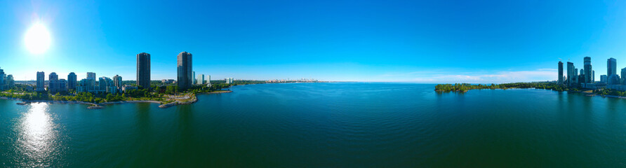 Obraz premium Artystyczny widok na miasto Humber Bay Shores Park i zieloną przestrzeń z panoramą miasta, lazurowe jezioro Ontario. Wieżowce nad Queensway o zachodzie słońca w lecie, Etobicoke, Ontario, Kanada