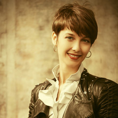 Happy young fashion woman in leather jacket with pixie hair style