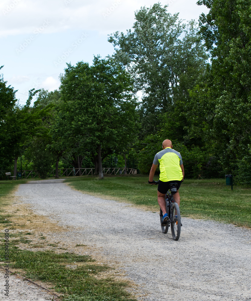 Wall mural man cycling in a park in italy after the coronavirus lockdown