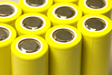Closeup of yellow pile of li-ion batteries, type 18650. Top And angle View. Focus with shallow...