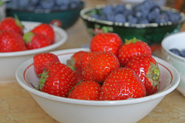 Plates with strawberries and blueberries on the table