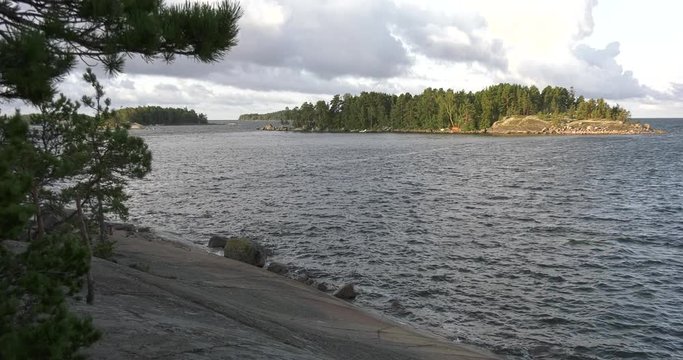 4K summer morning high quality video of Santalahti Baltic Sea Finnish Bay lagoon, pine tree forest beach with red granite boulders, lone island beach near Kotka, Finland Suomi, northern Europe
