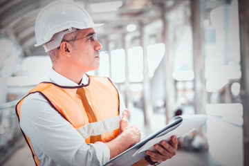 Senior men wear formal wear and protective hard hats. They are looking and carrying project documentation. In the concept of engineers and architects that monitor and monitor the progress of work