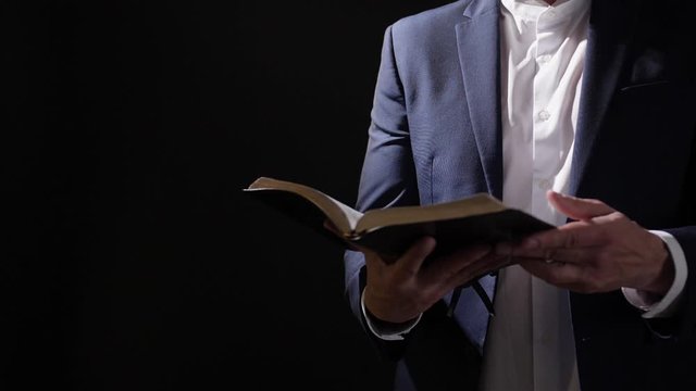 Man with Holy Bible on dark background
