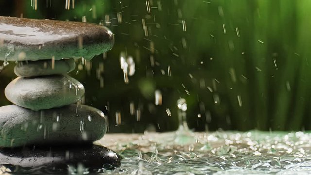 Rain in oriental garden with stack of zen stones