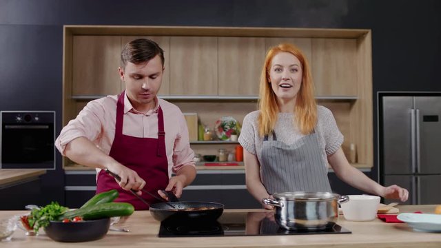 Cooking show hosts chefs, male and female, cooking meat. Morning TV cooking programme. Shot on ARRI Alexa Mini