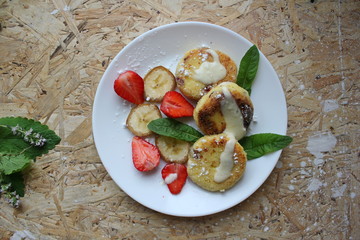 strawberry and cream. Cottage cheese pancakes cottage cheese with strawberry, mint, and banana. Ukrainian traditional food. Ukrainian national kitchen.