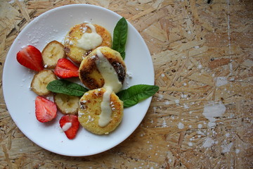 strawberry and cream. Cottage cheese pancakes cottage cheese with strawberry, mint, and banana. Ukrainian traditional food. Ukrainian national kitchen.