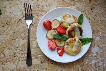 strawberry and cream. Cottage cheese pancakes cottage cheese with strawberry, mint, and banana. Ukrainian traditional food. Ukrainian national kitchen.
