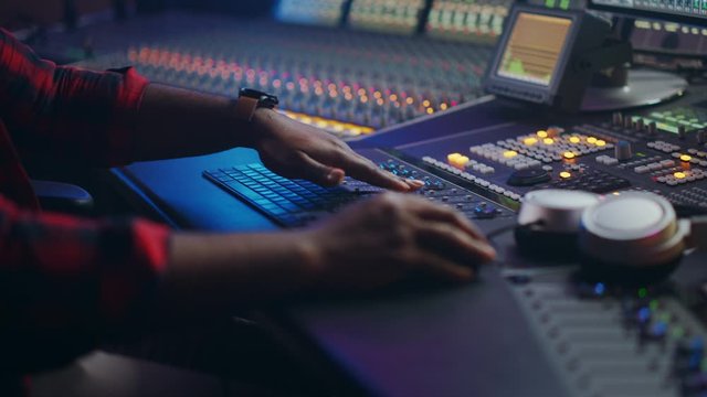 Music Creator, Musician, Artist Works in the Music Record Studio, Uses Surface Control Desk Equalizer Mixer. Buttons, Faders, Sliders to Broadcast, Record, Play Hit Song. Close-up Focus on Hands