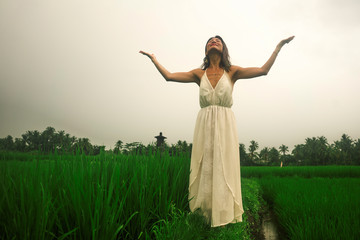 Naklejka na ściany i meble body and mind connection with nature - happy and beautiful Asian Japanese woman doing yoga and meditation exercise outdoors at idyllic green rice field enjoying tropical holidays