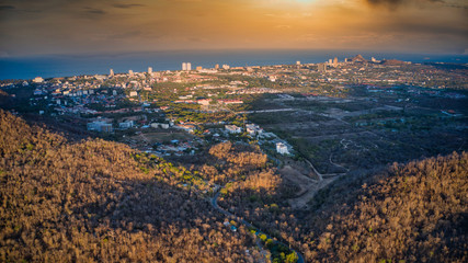 This unique photo shows the autumnal hilly landscape on the Hin lek fai during a sunset! The beautiful golden sky over the city of Hua Hin in the background. The picture was taken with a drone.