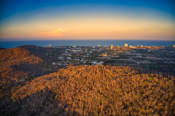 This unique photo shows the autumnal hilly landscape on the Hin lek fai during a sunset! The beautiful golden sky over the city of Hua Hin in the background. The picture was taken with a drone.