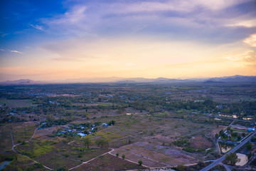 This unique photo shows the back landscape of Hua Hin in Thailand during a sunset with a great sky. You can also see a mountain range in the back.