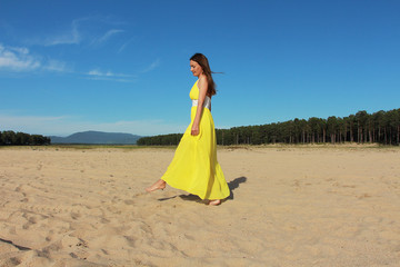 girl in a yellow dress on a sandy beach
