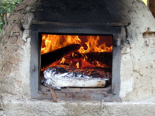Preparing the roast in the wood oven