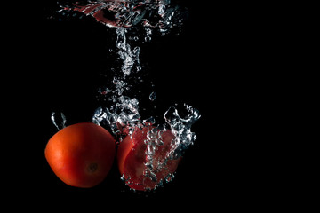 tomato entering the water and splashing