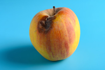 rotten apple on a blue background