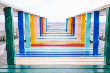 A famous colorful rainbow wooden bridge tourist attractions in Thailand.The color of LGBTQ.View of The colorful wood bridge extends into the sea that create for promote local place for traveling.