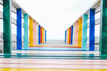 A famous colorful rainbow wooden bridge tourist attractions in Thailand.The color of LGBTQ.View of The colorful wood bridge extends into the sea that create for promote local place for traveling.