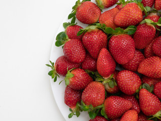 Top view. Copy space. Many strawberries in the white dish and white background.
