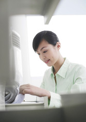 Businesswoman looking through file cabinet