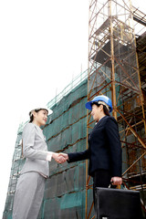 Businesswomen shaking hands at construction site