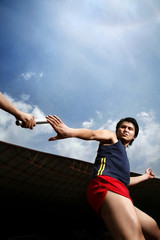 Man passing baton to his teammate in a relay event
