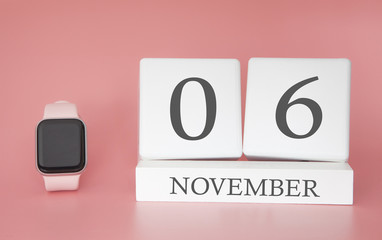 Modern Watch with cube calendar and date 06 november on pink background. Concept autumn time vacation.