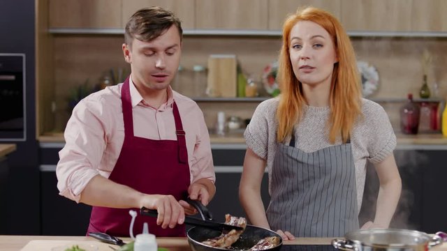 Cooking show hosts chefs, male and female, cooking meat. Morning TV cooking programme. Shot on ARRI Alexa Mini