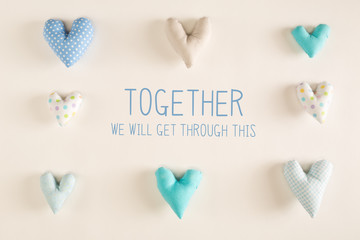 Together We Will Get Through This message with blue heart cushions on a white paper background