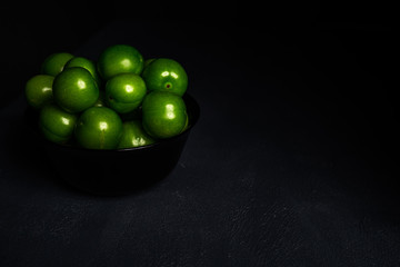 Close-up macro fresh green sour plum. Greengage on dark background.