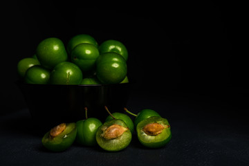 Close-up macro fresh green sour plum. Greengage on dark background.