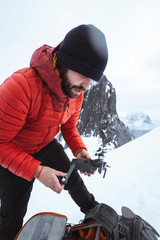 Fototapeta na wymiar Backpacker setting up a drone in the snowy Segla mountain, Norway