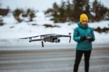 Woman flying a drone in Lofoten, Norway