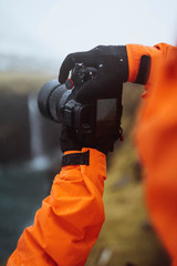 Photographer at Múlafossur waterfall in the Faroe Islands, part of the Kingdom of Denmark