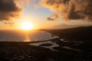 The intense light of the sun leaves the silhouette of Honolulu's coast. 