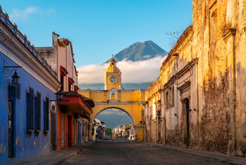 The Santa Catalina Arch in the Main Street of Antigua City without people and the Agua Volcano in...