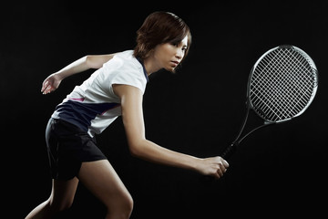 Woman with tennis racquet preparing to hit