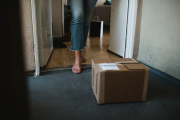 Woman getting her package from the front door during the coronavirus pandemic