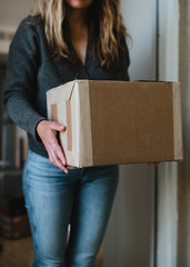 Woman getting her package from the front door during the coronavirus pandemic