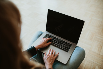 Woman working from home using a laptop screen mockup