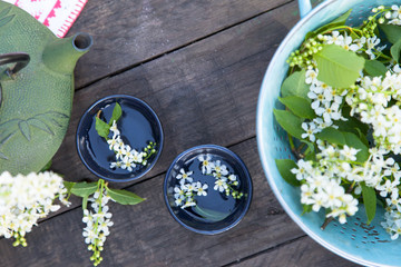 beautiful garden fresh flower tea kettle on wooden table outdoor setting, herbal floral background
